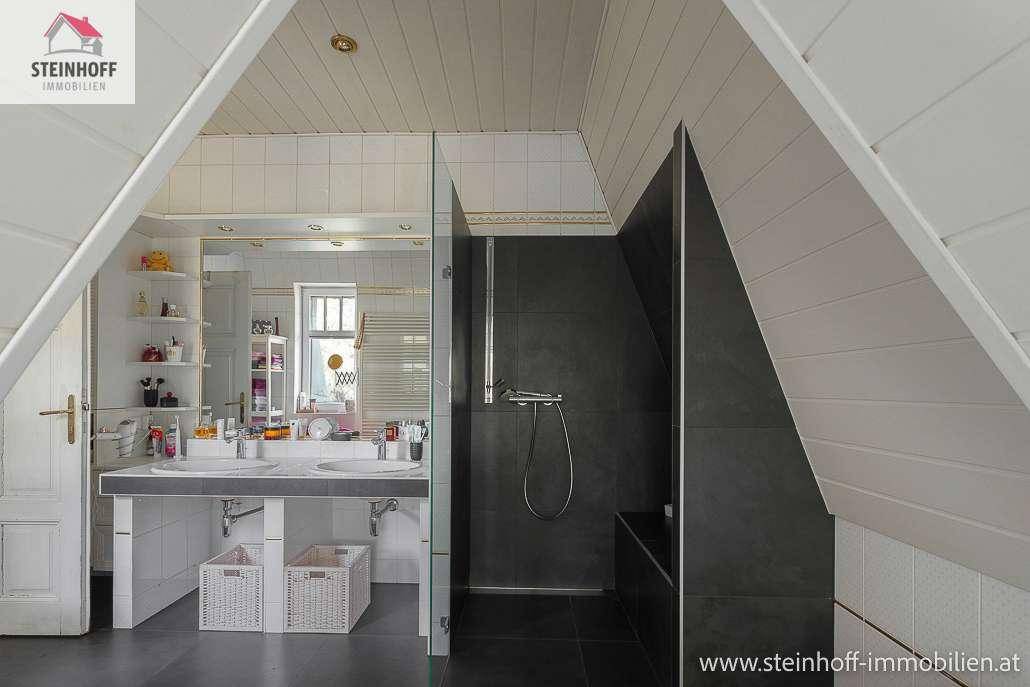 Modernes Badezimmer mit begehbarer Dusche, Doppelwaschbecken und Dachschräge.