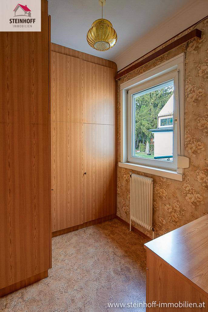 Zimmer mit großem Einbauschrank und Fenster, das Tageslicht hereinlässt.