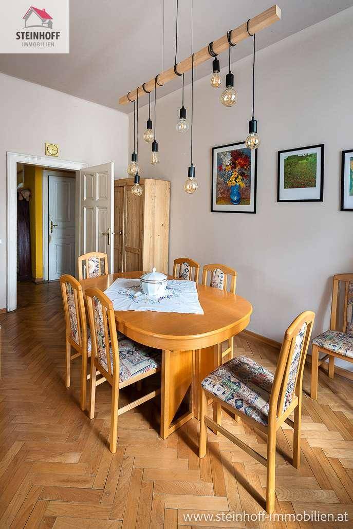 Esszimmer mit ovalem Holztisch, passenden Stühlen und moderner Hängelampe.