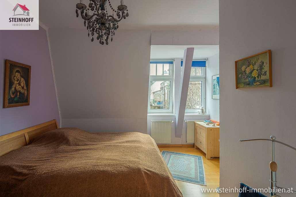 Gemütliches Schlafzimmer im Dachgeschoss mit Dachschräge, Holzboden und natürlichem Licht.