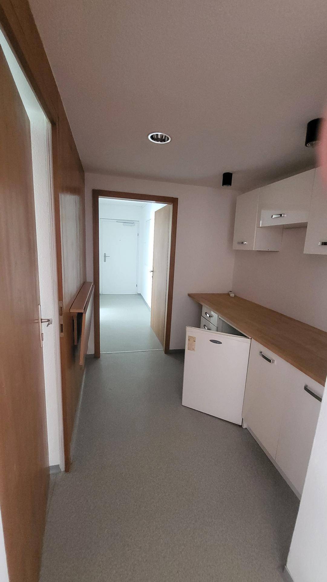 Flur mit Holzvertäfelung, Einbauschränken und einer kleinen Küchenzeile oder Arbeitsfläche.