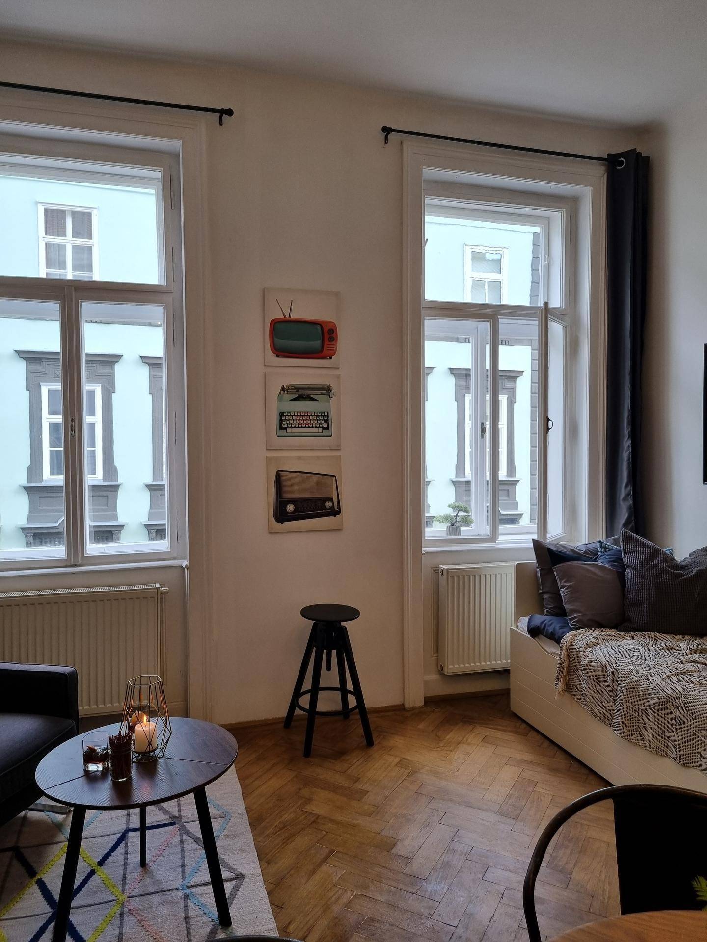 Lichtdurchfluteter Wohnbereich mit großen Fenstern, Tagesbett und Couchtisch.