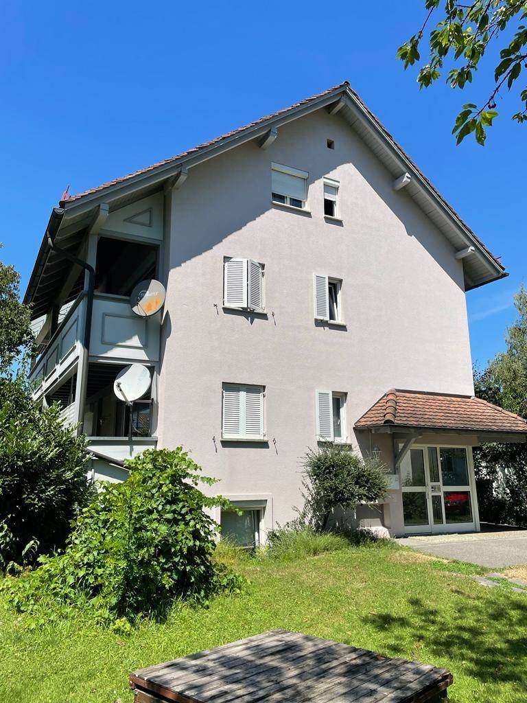 Rückseite des Hauses mit mehreren Balkonen und einem überdachten Eingangsbereich.