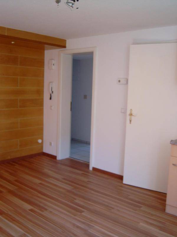 Heller Raum mit Holzboden und einer dekorativen Holzvertäfelung an der Wand.