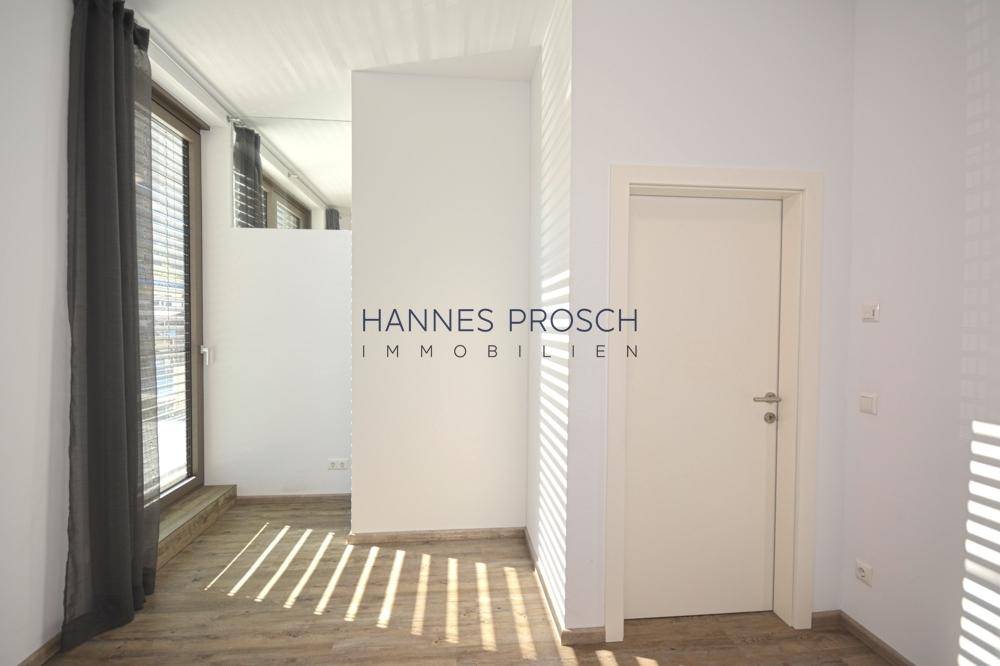 Heller Flurbereich mit Laminatboden und Zugang zu weiteren Räumen.