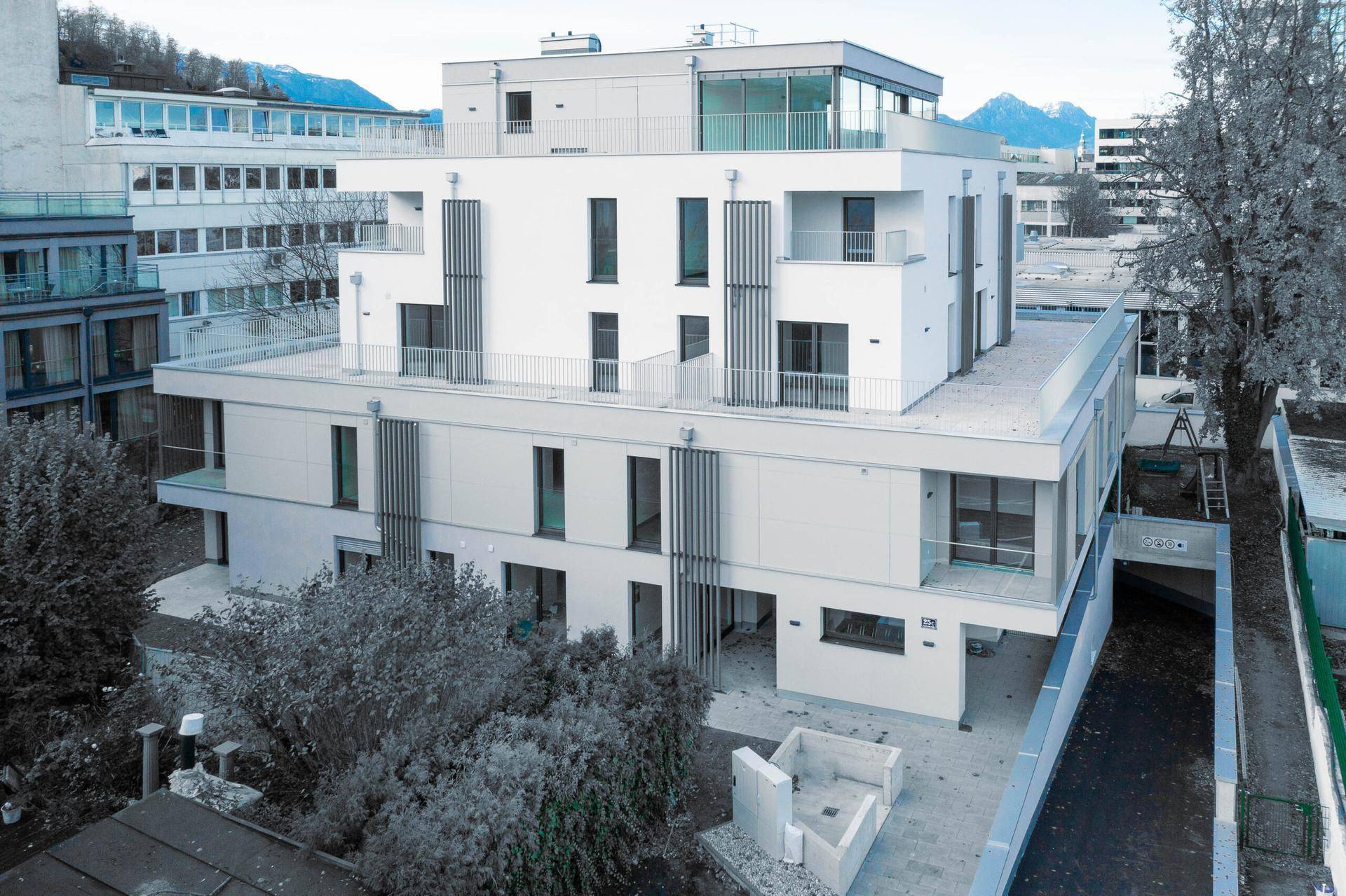 Modernes Wohnhaus mit klaren Linien, großen Fenstern und begrüntem Umfeld.