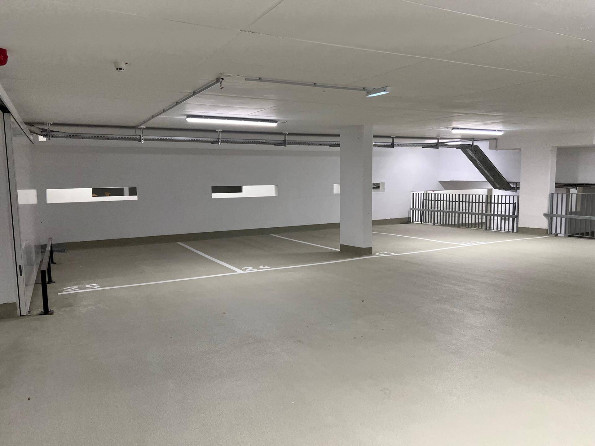 Geräumige Tiefgarage mit Fahrradabstellbereich und mehreren Stellplätzen in modernem Design.