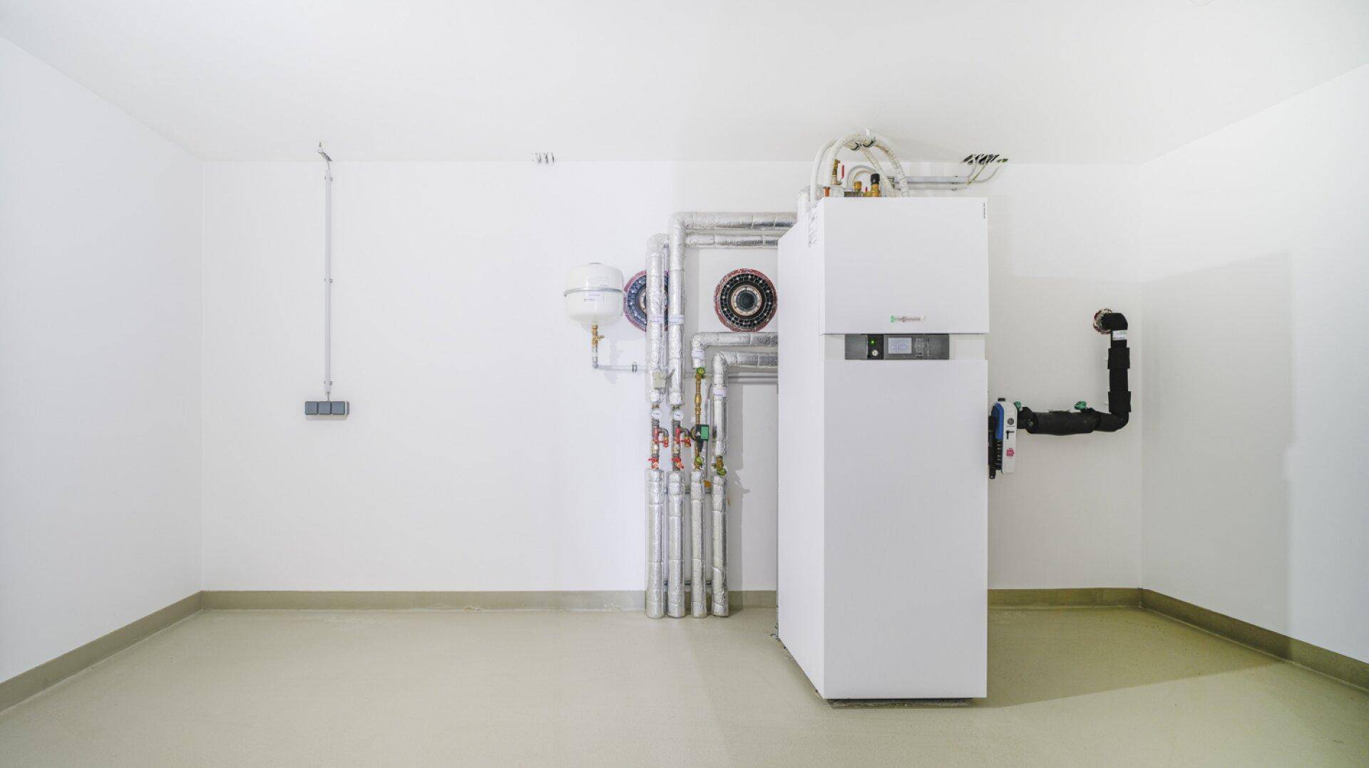 Technikraum mit moderner Heizungsanlage und Rohrleitungen in einem sauberen Zustand.