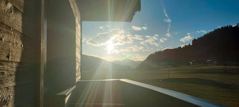 Malerischer Sonnenuntergang über den Bergen, gesehen von einem Balkon oder Fenster der Immobilie.