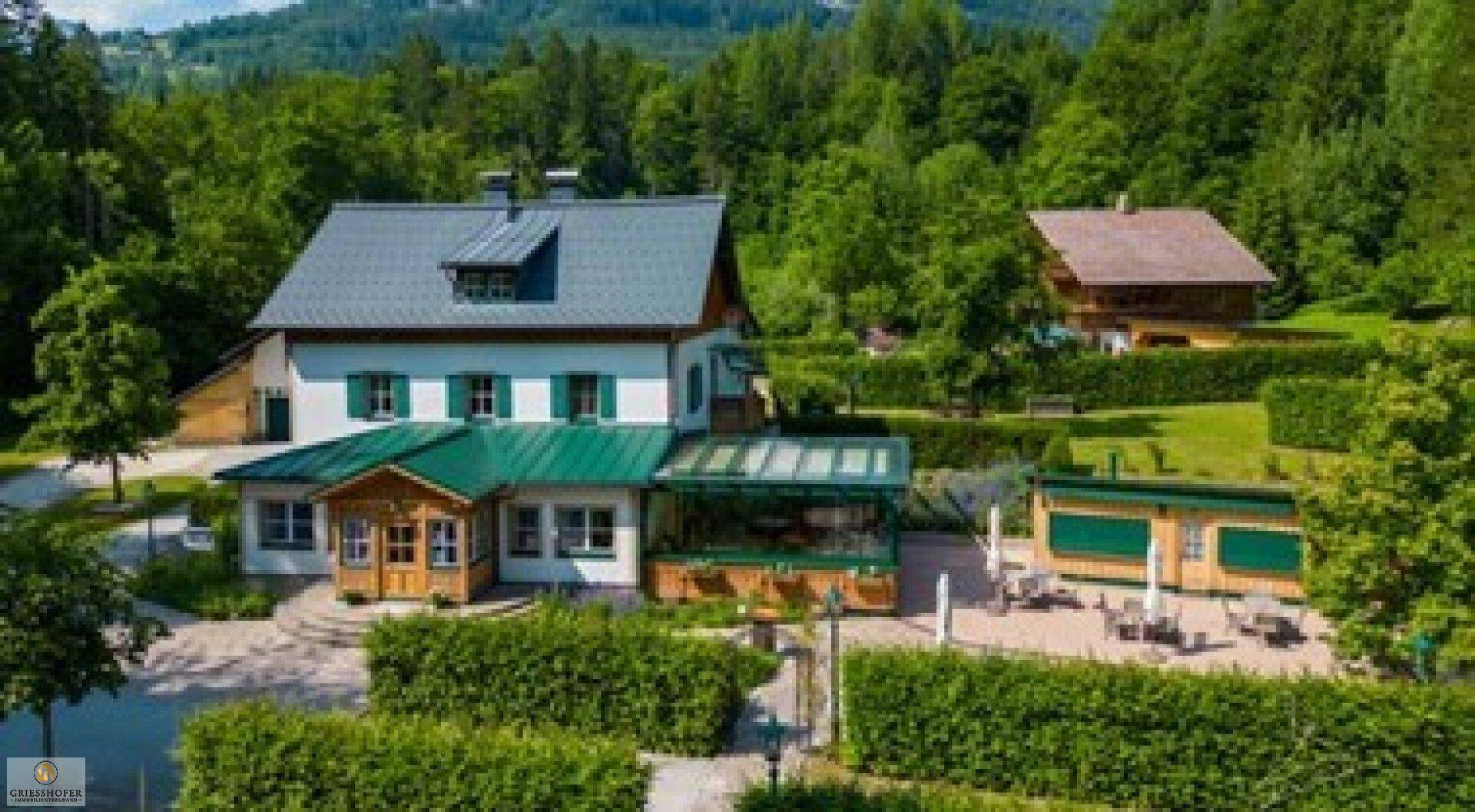 Anwesen mit Haupthaus, Nebengebäuden und großzügiger Außenanlage im Grünen.