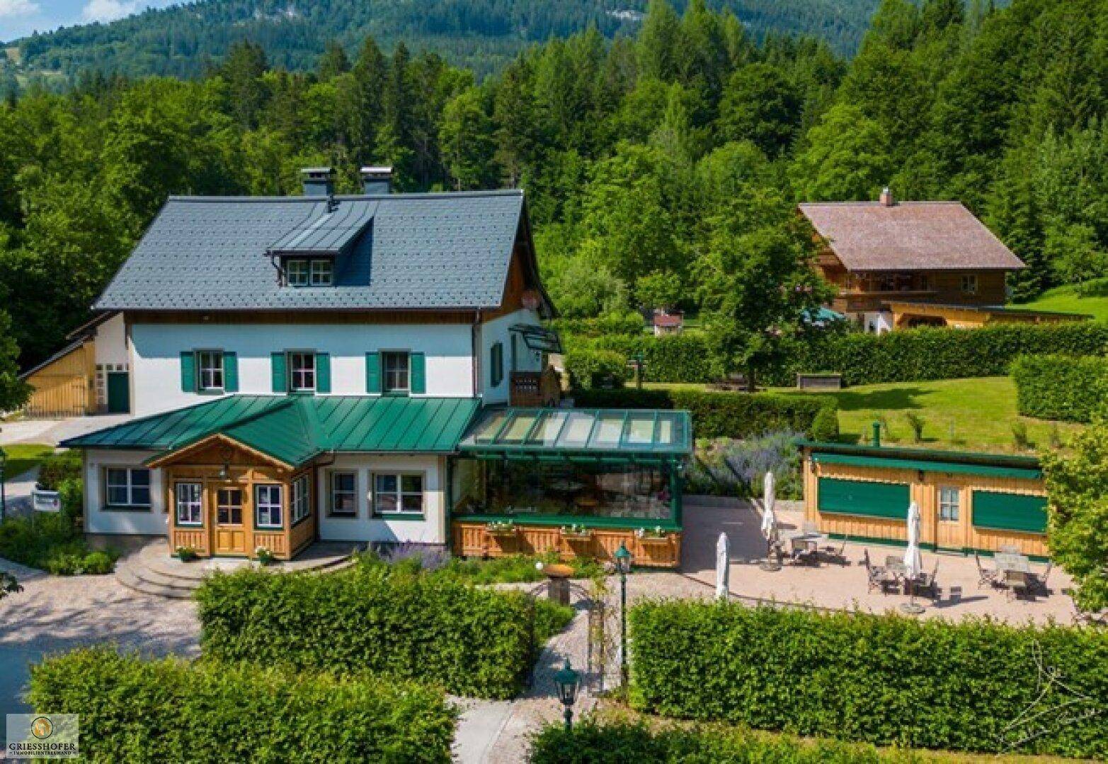 Großes Anwesen mit Haupthaus, Nebengebäuden und weitläufigem Gartenbereich.
