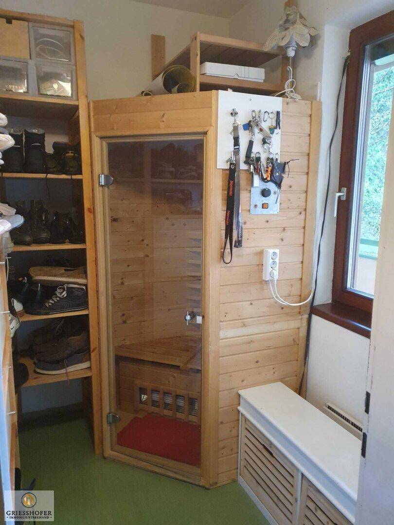 Kleiner Raum mit eingebauter Sauna und praktischen Regalen für Stauraum.