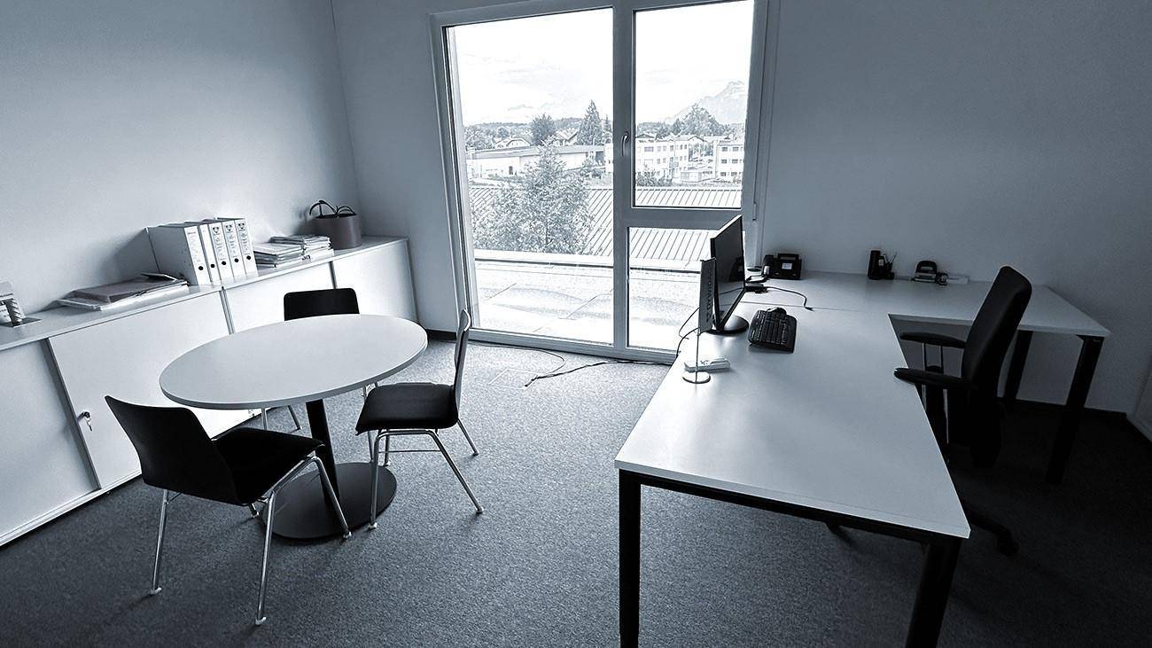 Helles Büro mit großen Fenstern, Schreibtischen und Blick auf die ländliche Umgebung.