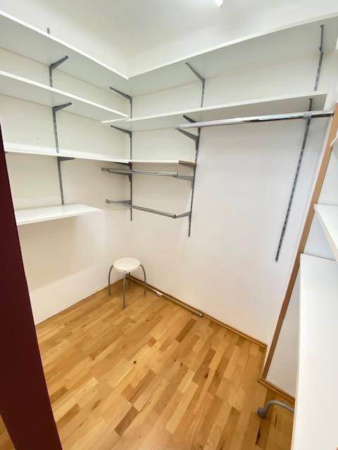 Praktischer begehbarer Kleiderschrank mit Regalen und Kleiderstangen für viel Stauraum.