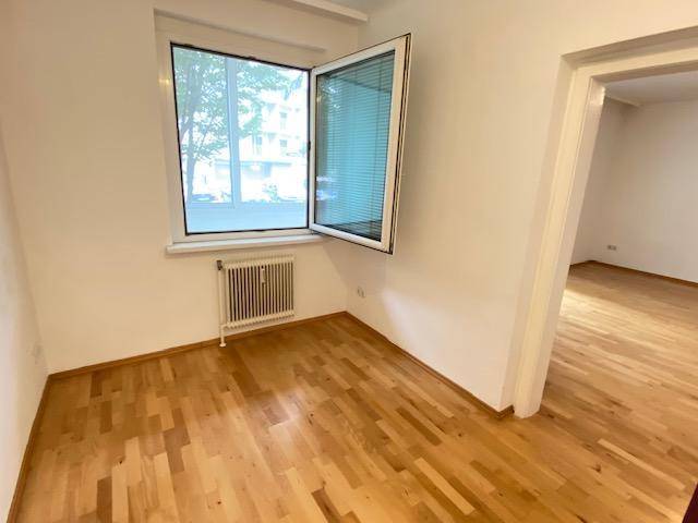 Weiteres helles Zimmer mit Parkettboden und großem Fenster, vielseitig nutzbar.