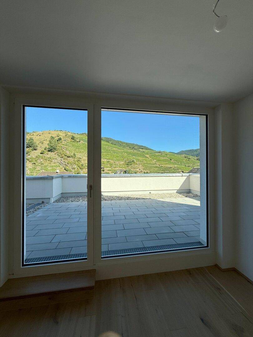 Große Fensterfront bietet einen weiten Blick auf die umliegenden Weinberge und die Landschaft.