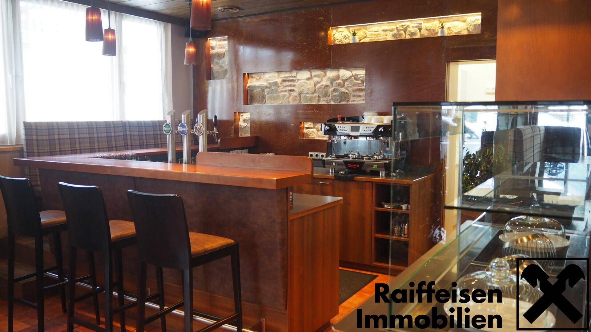 Moderne Bar mit Holzelementen, Zapfanlage und Kaffeemaschine, umgeben von rustikalen Steinwänden und warmem Licht.