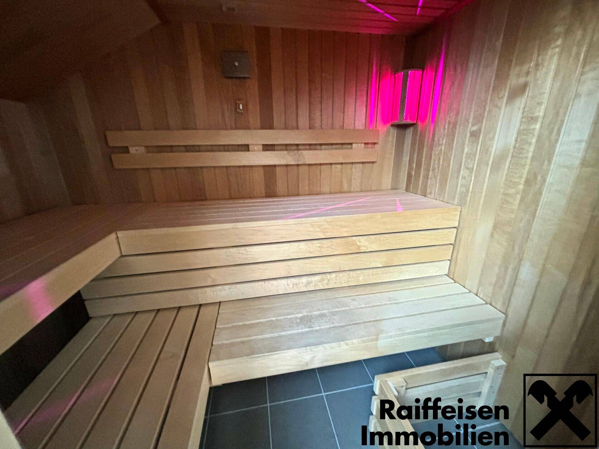 Innenansicht einer modernen Sauna mit Holzverkleidung und mehrstufigen Sitzbänken.