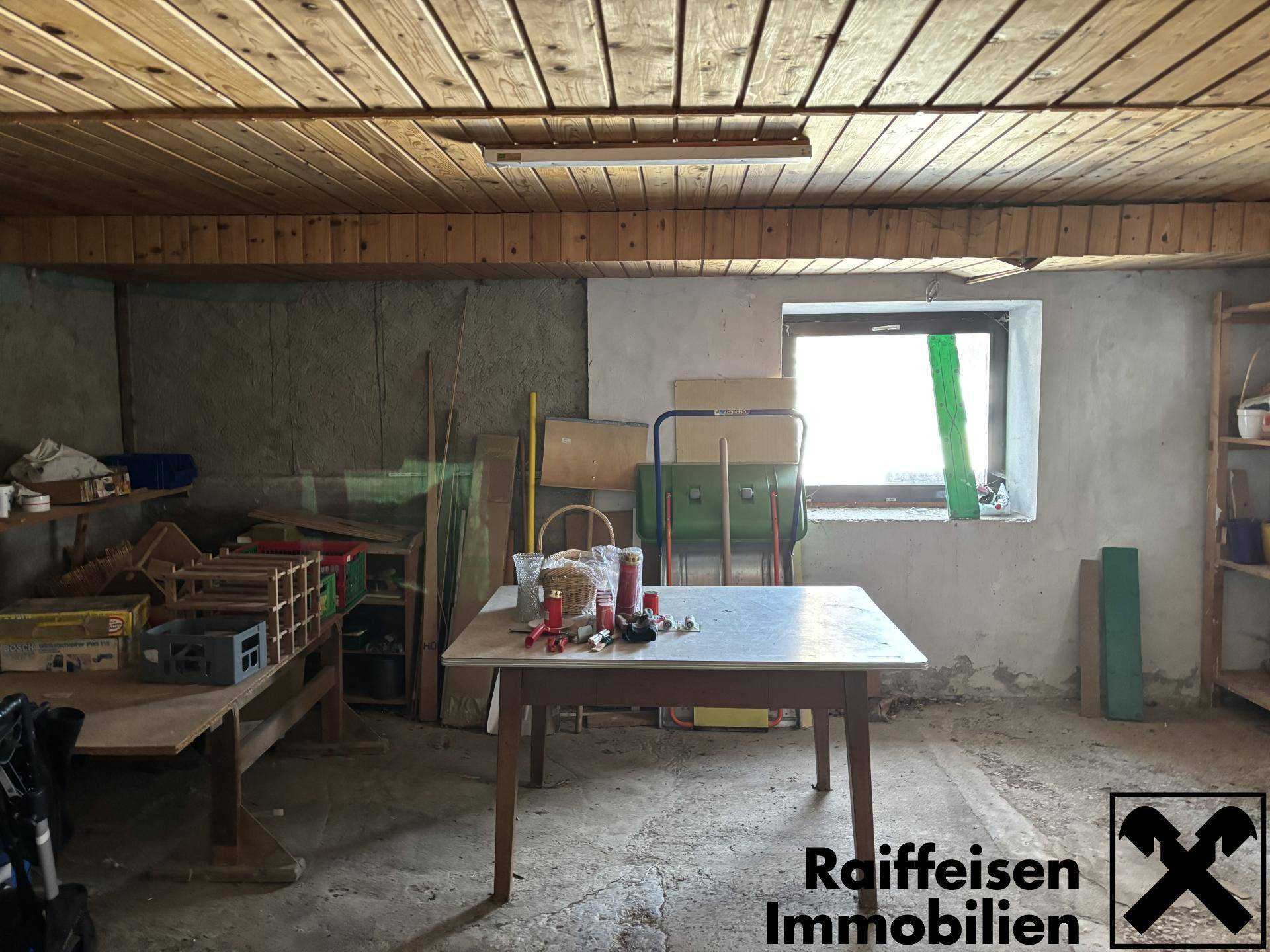 Geräumiger Abstellraum mit Holztäfelung an der Decke und einem Fenster.