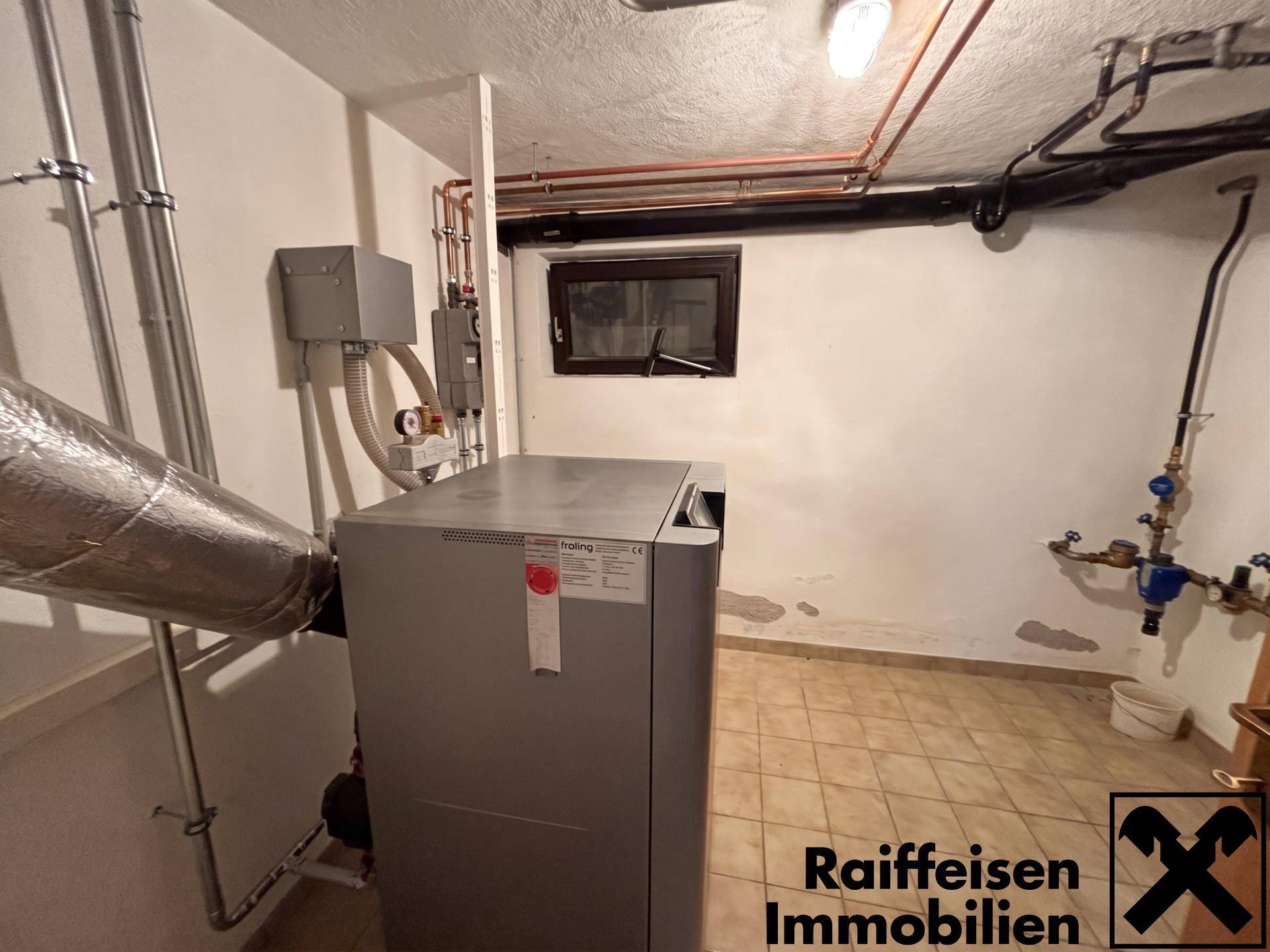 Heizungsraum im Keller mit moderner Heizungsanlage und sichtbaren Rohrleitungen.