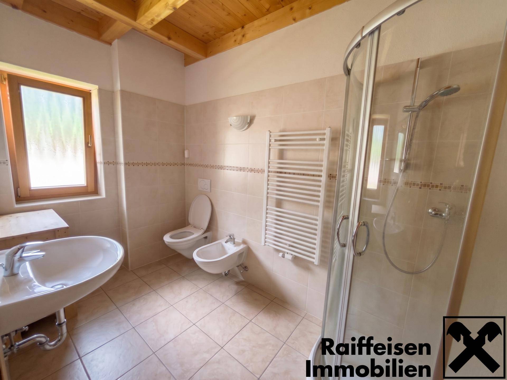 Helles Badezimmer mit Dusche, WC, Bidet und beheiztem Handtuchhalter.