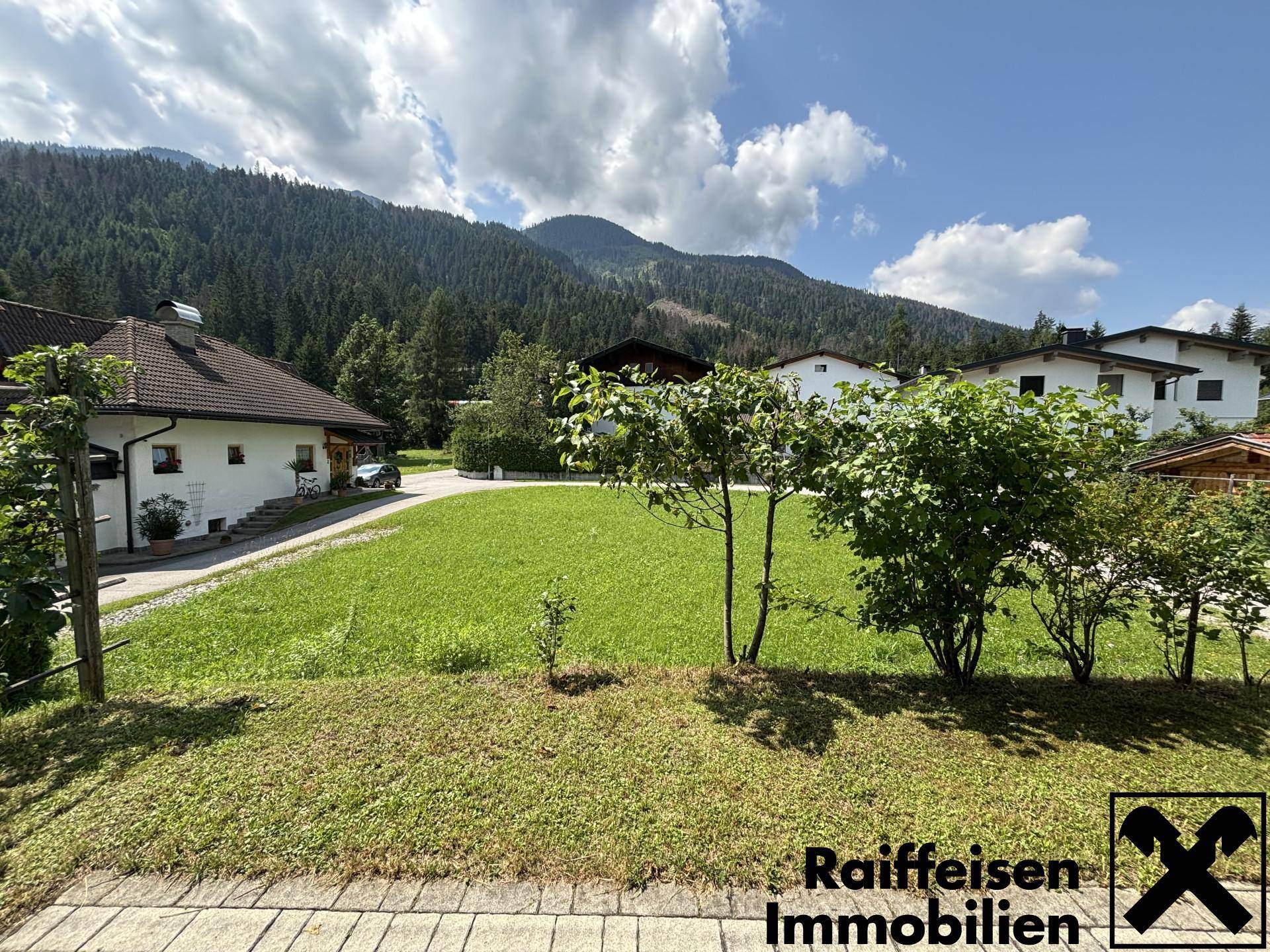 Weitläufiger Gartenbereich mit Rasenfläche und Blick auf die umliegende Berglandschaft.