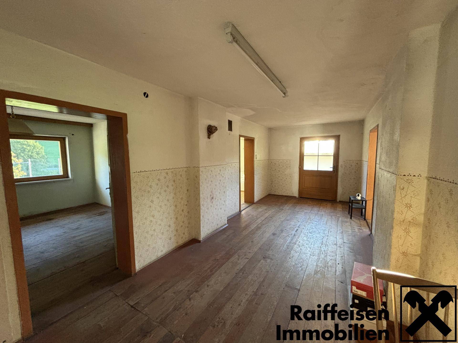 Geräumiger Flur mit Holzdielenboden und traditioneller Wandgestaltung, führt zu weiteren Räumen.