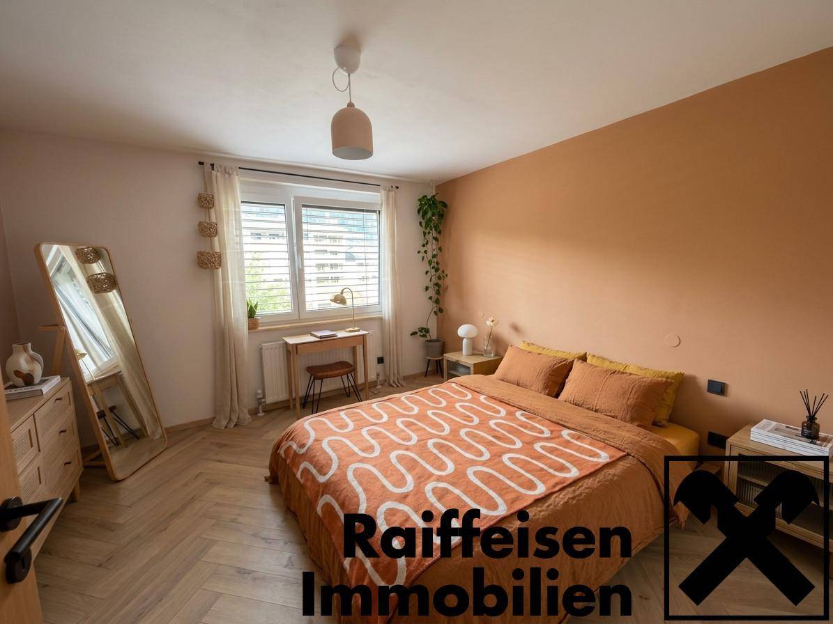 Gemütliches Schlafzimmer mit warmen Farbtönen, Holzfußboden und großem Spiegel.