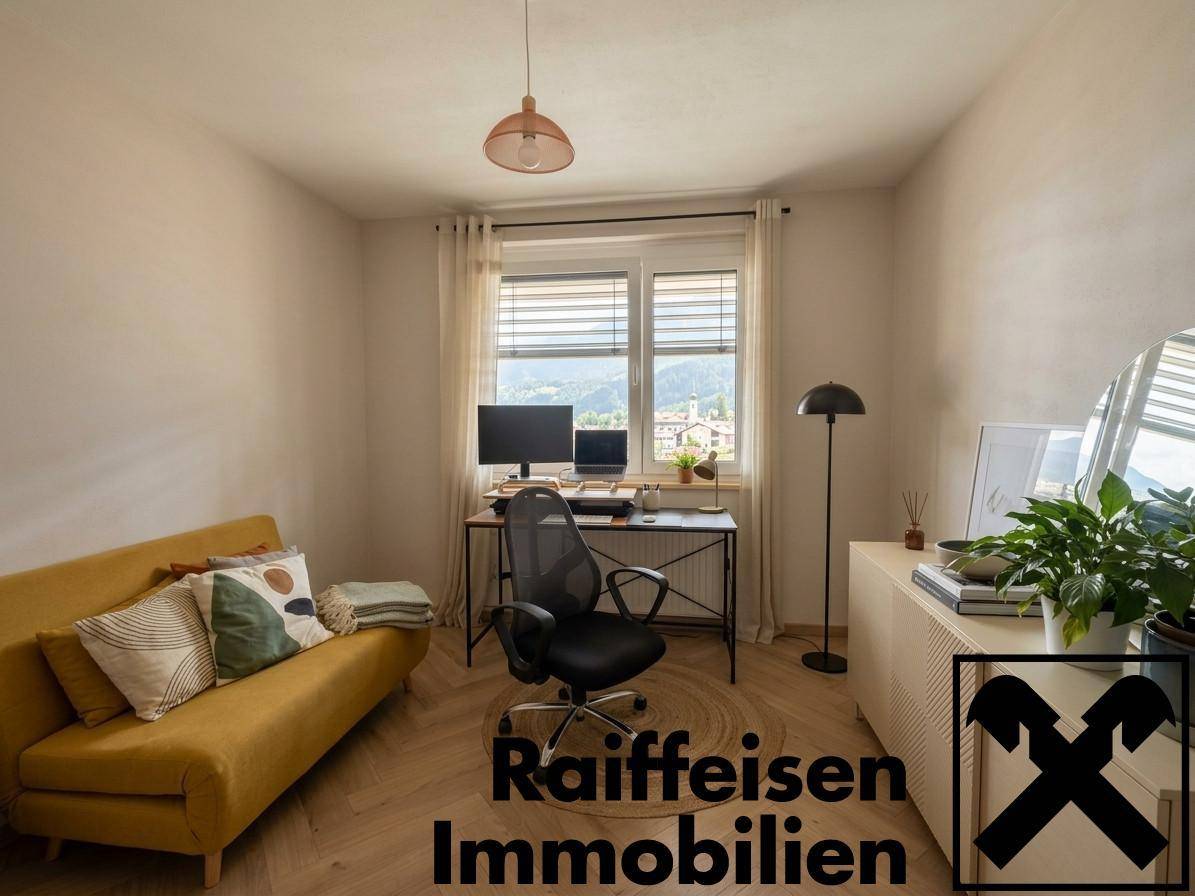 Funktionales Arbeitszimmer mit Schreibtisch, gelbem Sofa und Blick ins Grüne.