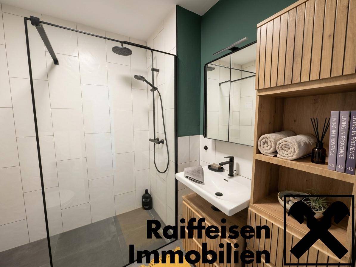 Modernes Badezimmer mit begehbarer Dusche, Holzregalen und grüner Akzentwand.