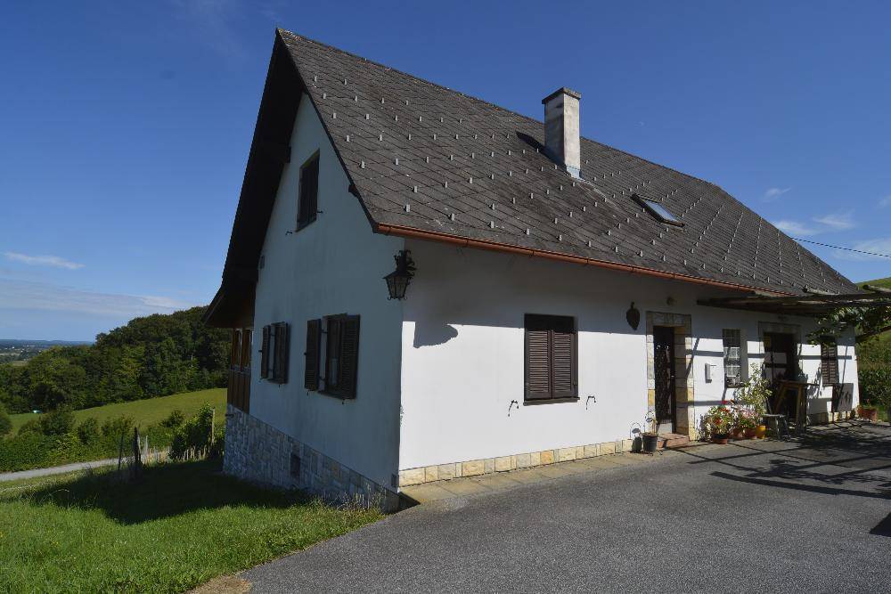 Haus aus erhöhter Perspektive mit Satteldach und Schornstein, umgeben von einer weiten Landschaft.
