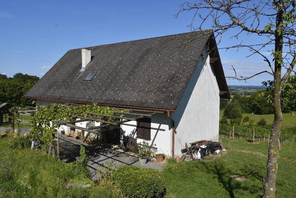 Vogelperspektive des Hauses mit Satteldach, Pergola und umliegenden Weinbergen in sonniger Lage.