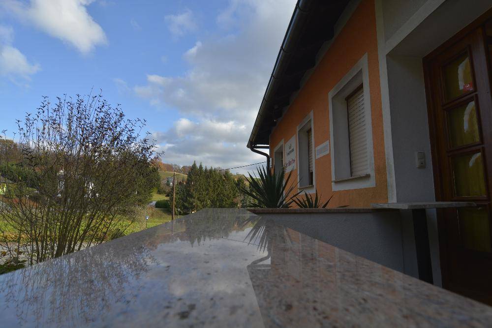 Granitoberfläche, möglicherweise ein Balkongeländer, mit Blick auf die Landschaft.