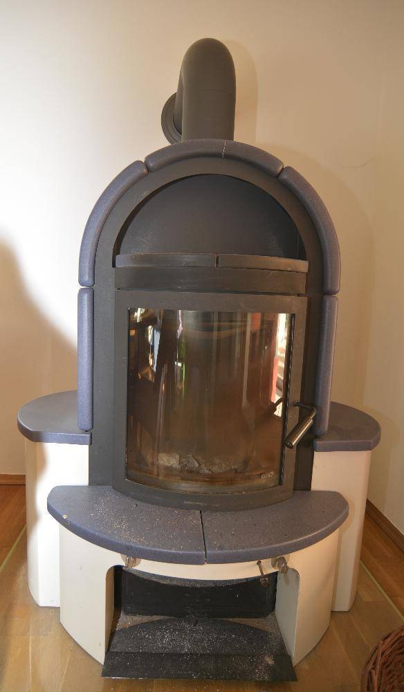 Moderner Kaminofen mit Glaseinsatz und blauen Akzenten im Wohnbereich.