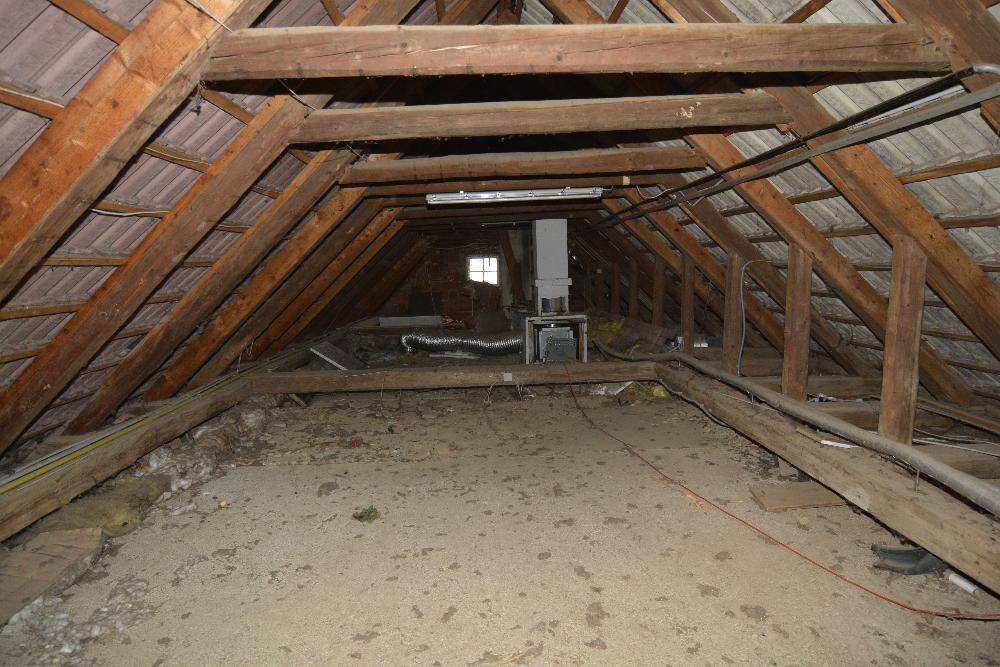 Unausgebauter Dachboden mit sichtbaren Holzbalken und Dachkonstruktion, bietet Ausbaupotenzial.