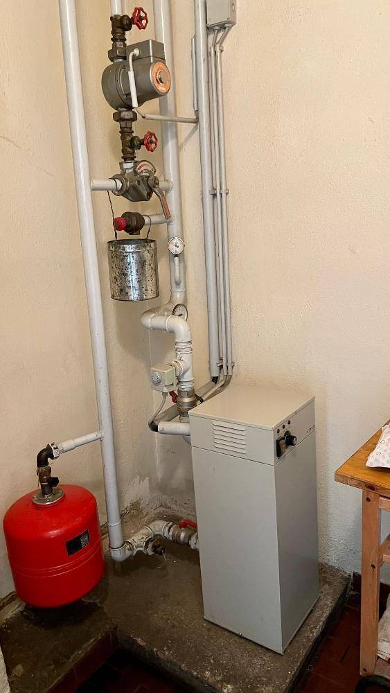 Hauswirtschaftsraum mit Heizungsanlage und Rohren an der Wand, in einfachem Zustand.