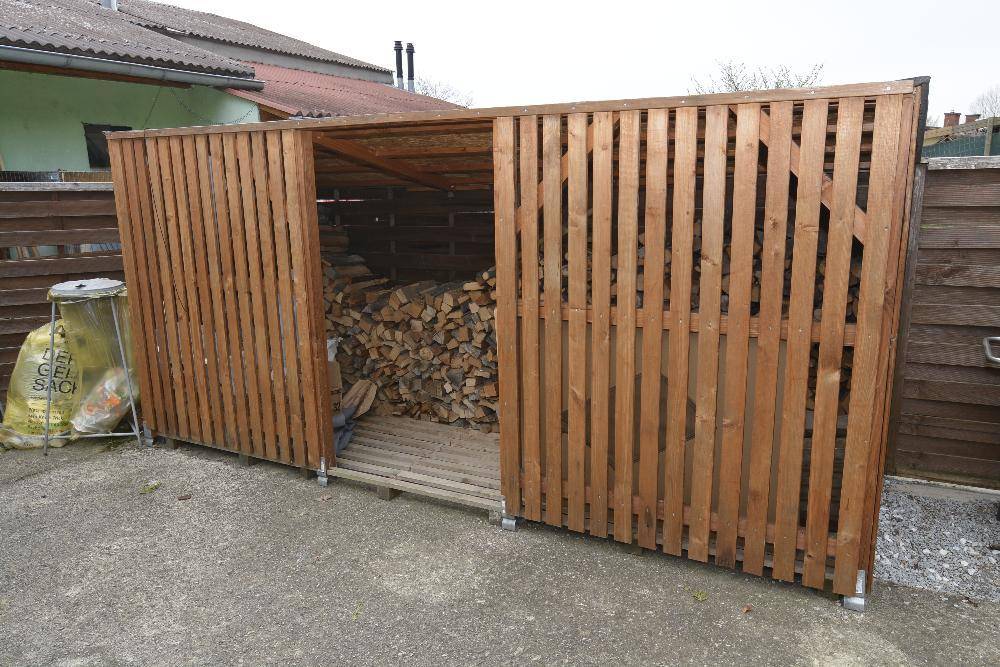 Holzschuppen gefüllt mit Brennholz, bereit für die kalte Jahreszeit.