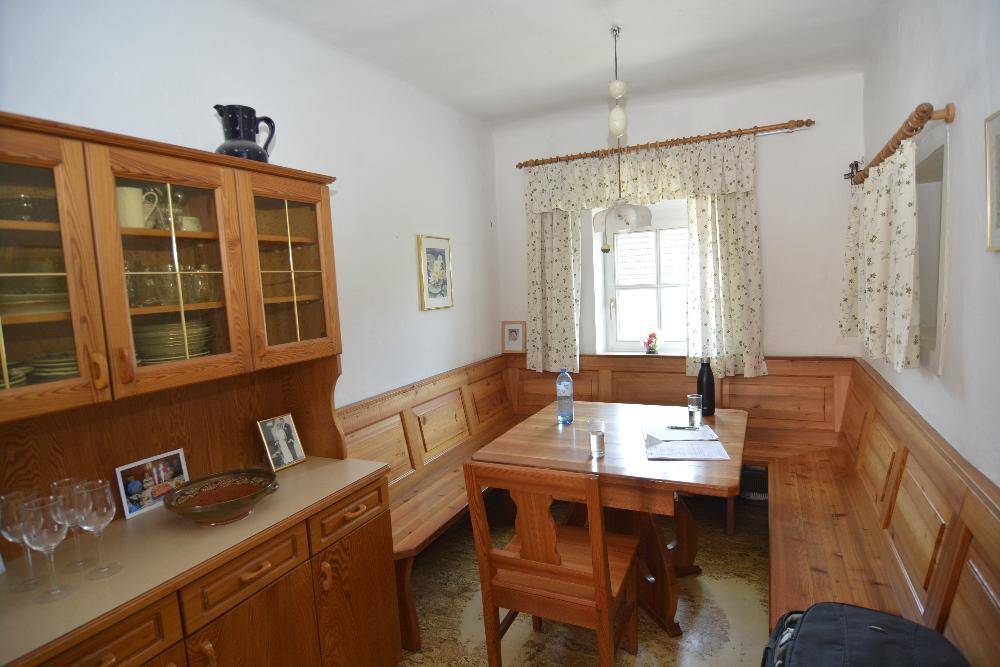 Gemütlicher Essbereich mit Holzbänken, Esstisch und einem Buffetschrank im Landhausstil.