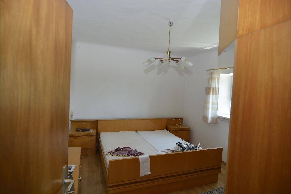 Helles Schlafzimmer mit Doppelbett, Holzmöbeln und einem Fenster.