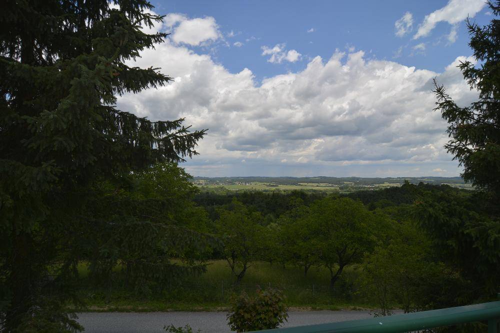 Weitläufiger Panoramablick über die hügelige Landschaft mit Wäldern und Feldern.