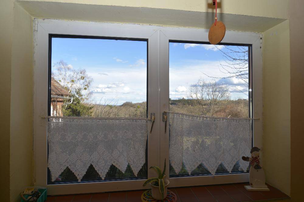 Fenster mit Blick auf die weite Landschaft und den Himmel.
