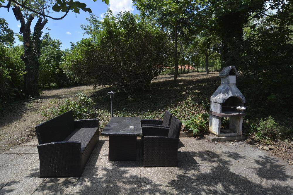 Gemütlicher Terrassenbereich mit Outdoor-Sitzmöbeln und einem gemauerten Grill für gesellige Abende.