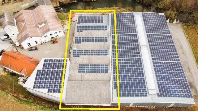 Luftaufnahme des Gebäudes mit zahlreichen Photovoltaikmodulen auf dem Dach zur Energiegewinnung.