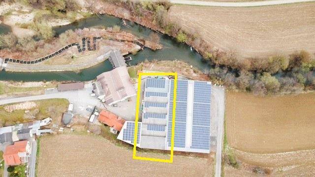 Weitläufige Luftaufnahme des Anwesens mit Solaranlagen und einem Fluss in der Nähe.