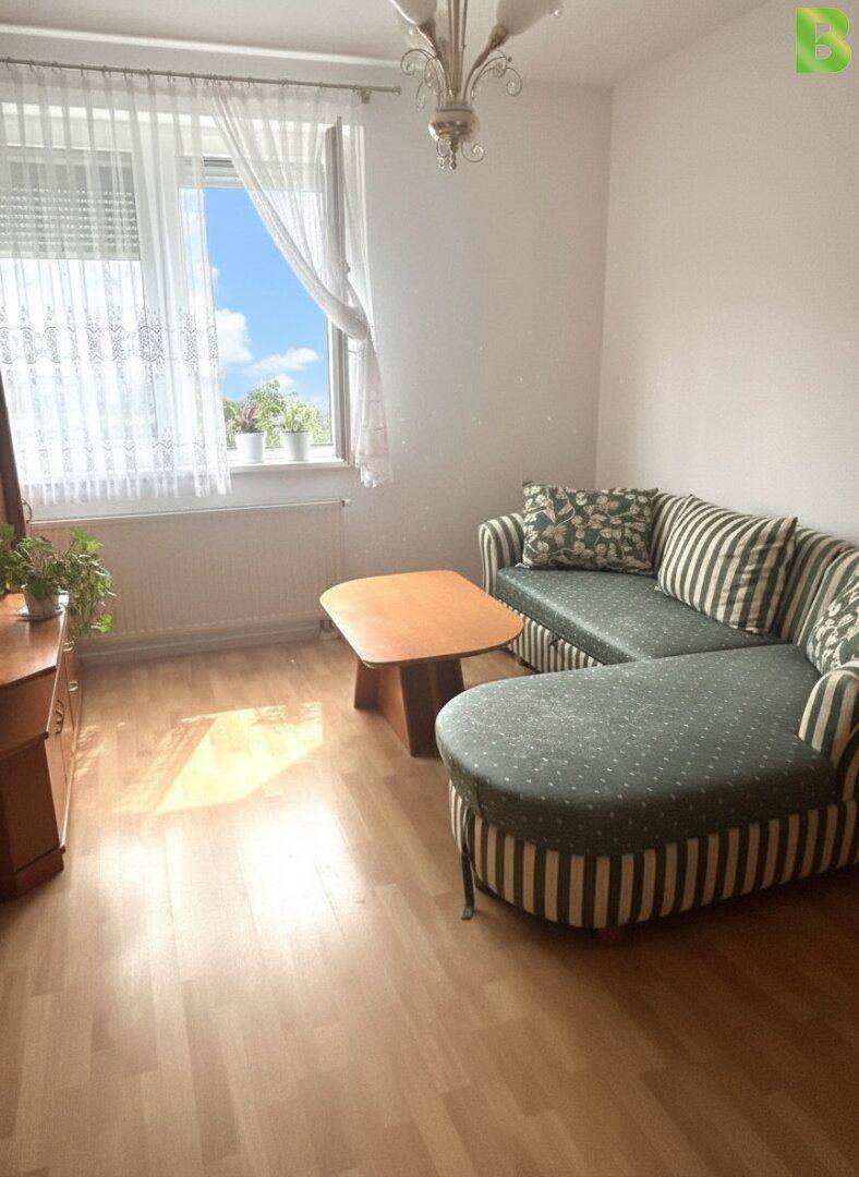 Gemütliches Wohnzimmer mit gestreifter Couch, Holztisch und hellem Parkettboden.