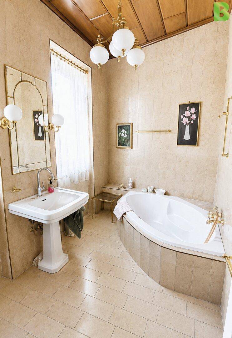 Klassisches Badezimmer mit Badewanne, Waschtisch und Fenster.