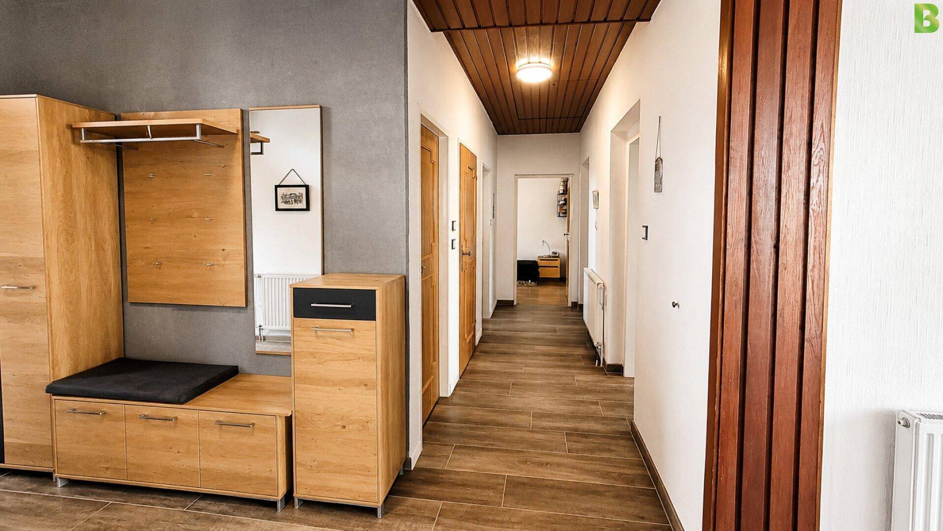 Heller Flur mit Holzdecke, Garderobe und Zugang zu weiteren Räumen.