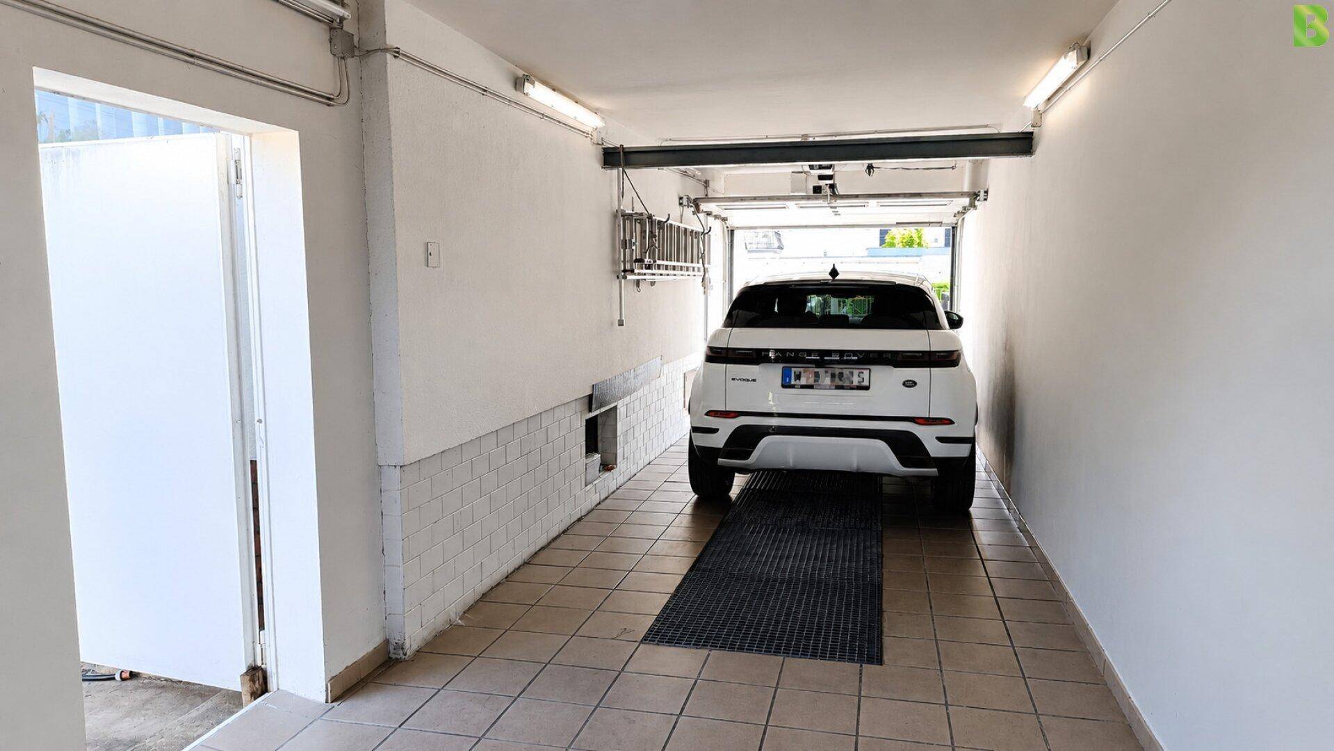 Garage mit Fliesenboden und Platz für ein Fahrzeug.