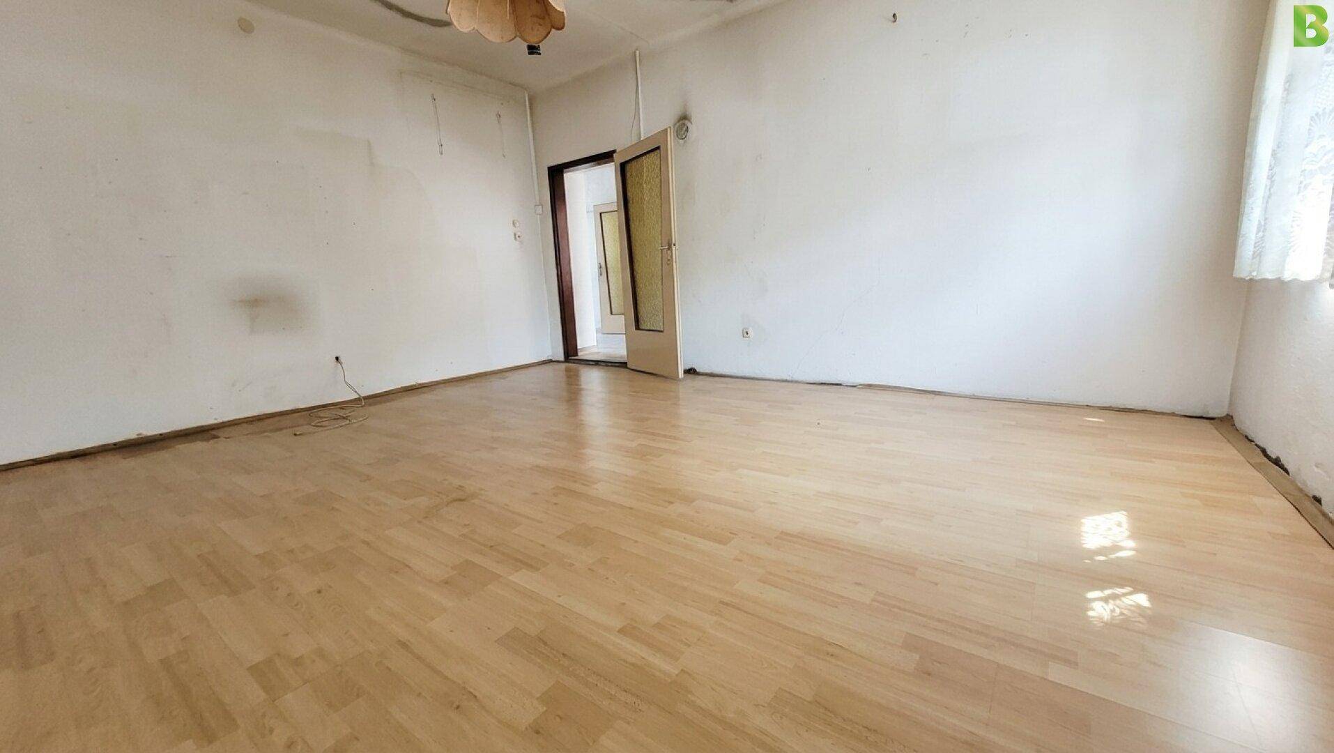 Geräumiges, unmöbliertes Zimmer mit hellem Laminatboden und viel Potenzial zur Gestaltung.
