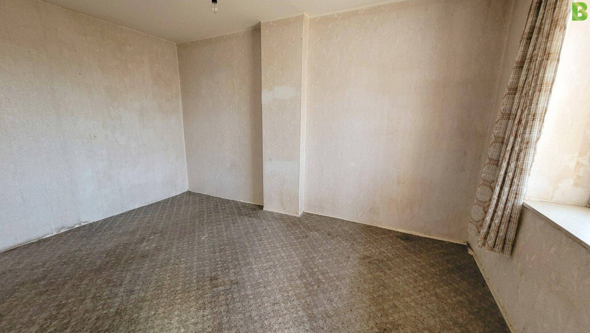 Einfaches, unmöbliertes Zimmer mit Teppichboden und Fenster, ideal als Schlaf- oder Kinderzimmer.